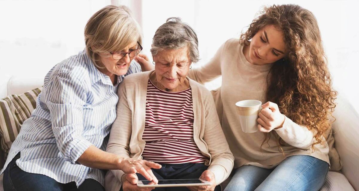 three people looking at an iPad