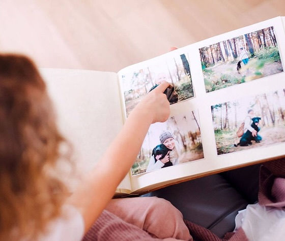 a girl pointing at a photo album
